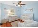 Bedroom features hardwood floors, a ceiling fan, a white crib and accenting floral wall art at 3939 Sussex Ave, Charlotte, NC 28210