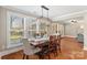 Bright dining area with hardwood floors, a stylish light fixture, and large windows offering backyard views at 3939 Sussex Ave, Charlotte, NC 28210