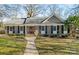 Charming brick home featuring manicured landscaping, black shutters, and a welcoming walkway to the front door at 3939 Sussex Ave, Charlotte, NC 28210