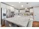 A chef's kitchen features stainless appliances, white cabinetry, a kitchen island, and barstool seating with pendant lighting at 3939 Sussex Ave, Charlotte, NC 28210