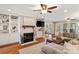 Open-concept living room with a white brick fireplace, built-in shelves, and hardwood floors at 3939 Sussex Ave, Charlotte, NC 28210