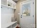 Welcoming mudroom with a built-in bench, hooks, and a well-lit door to the outside at 3939 Sussex Ave, Charlotte, NC 28210