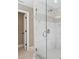 A stand-alone shower features glass doors, marble tiling, a built-in seat, and modern fixtures and hardware at 3939 Sussex Ave, Charlotte, NC 28210