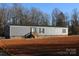 Gray mobile home with brick skirting, steps, and a small yard at 426 Sellerstown Rd, Kings Mountain, NC 28086