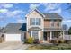 Two-story house featuring brick and siding, a gray roof, and a landscaped front yard at 4301 Windjammer Sw Ct, Concord, NC 28027