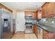 Modern kitchen with stainless steel appliances, wood cabinets, and granite counters at 4301 Windjammer Sw Ct, Concord, NC 28027