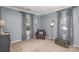 Well-lit living room with comfortable armchair and two windows at 4763 Brockton Nw Ct, Concord, NC 28027