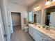 Well-lit bathroom with double sink vanity, tiled floors, framed mirrors and a walk-in closet at 5047 Summer Surprise Ln, Charlotte, NC 28215