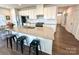 Modern kitchen with white cabinetry, granite countertops, stainless steel appliances, and island seating at 5047 Summer Surprise Ln, Charlotte, NC 28215