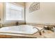 Relaxing corner jacuzzi tub with tile surround and window at 573 Church St, Locust, NC 28097