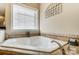 Relaxing corner jacuzzi tub with tile surround and window at 573 Church St, Locust, NC 28097