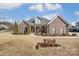 Brick home with landscaped yard, large windows and a welcoming porch at 573 Church St, Locust, NC 28097