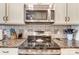 Kitchen detail showing a sleek, stainless steel stove top and microwave at 573 Church St, Locust, NC 28097