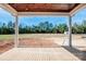 A covered back porch with wood ceiling and flooring, overlooking a spacious backyard with mature trees and open space at 6098 Ballard Rd, Denver, NC 28037