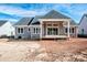 Back of house with covered patio, gray siding, and a dark gray roof, in a new construction community at 6098 Ballard Rd, Denver, NC 28037