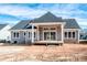 The back of a house with a covered patio, dark gray siding, a gray roof, and a spacious backyard at 6098 Ballard Rd, Denver, NC 28037