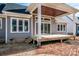 Backyard view showcasing the wood porch with a stained wood ceiling and steps leading to the yard at 6098 Ballard Rd, Denver, NC 28037