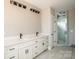 Bathroom with double sink vanity with matte black hardware and enclosed glass tiled shower at 6098 Ballard Rd, Denver, NC 28037