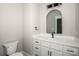 Modern bathroom with a white vanity, arched mirror, and contemporary black fixtures at 6098 Ballard Rd, Denver, NC 28037