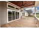 View of the home's wooden deck with ceiling fan and sliding glass doors at 6098 Ballard Rd, Denver, NC 28037