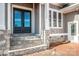 Stylish entrance with stone steps leading to a glass-paneled double door and white-trimmed windows at 6098 Ballard Rd, Denver, NC 28037