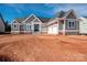 Newly built home with gray siding, stone foundation, and a three-car garage on a sunny day at 6098 Ballard Rd, Denver, NC 28037