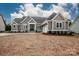 Charming gray home with white trim, double-door entry, stone accents, and attached two-car garage at 6098 Ballard Rd, Denver, NC 28037