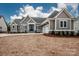 Charming gray home with white trim, double-door entry, stone accents, and attached two-car garage at 6098 Ballard Rd, Denver, NC 28037