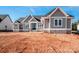 New home with gray siding, stone accents, a double-door entry, and a manicured yard on a sunny day at 6098 Ballard Rd, Denver, NC 28037