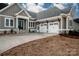 Attractive gray home featuring a double garage and stone-accented front steps leading to a covered entrance at 6098 Ballard Rd, Denver, NC 28037