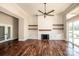 Bright living room with fireplace, custom shelving, hardwood floors, and sliding door access at 6098 Ballard Rd, Denver, NC 28037