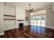 Bright living room with fireplace, custom shelving, hardwood floors, and sliding door access at 6098 Ballard Rd, Denver, NC 28037