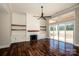 Bright living room with fireplace, custom shelving, hardwood floors, and sliding door access at 6098 Ballard Rd, Denver, NC 28037