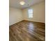 Bright bedroom features a window and wood-look flooring, ready for personal touches at 6140 Whispering Brook Ct, Charlotte, NC 28216