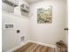 Functional laundry room with stylish wood-look flooring, shelving, and essential hookups for laundry appliances at 620 Cassidy Ct, Clover, SC 29710