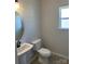 Bathroom with vanity sink, white toilet, and a round mirror with decorative lighting at 6332 Honor Ave, Midland, NC 28107