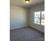 This bedroom features a large window with a neutral-toned carpet at 6332 Honor Ave, Midland, NC 28107