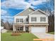 Two-story house with gray siding, stone accents, and a white garage door at 6332 Honor Ave, Midland, NC 28107