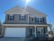 Charming two-story home with stone accents, gray siding, attached two car garage, and welcoming front porch at 6332 Honor Ave, Midland, NC 28107