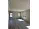 Sunlit living room with laminate flooring, neutral walls, three large windows, and recessed lighting at 6332 Honor Ave, Midland, NC 28107