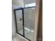 Modern bathroom shower featuring glass doors, gray tiling, and sleek black hardware at 6332 Honor Ave, Midland, NC 28107