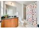 Bathroom with cherry vanity, shower, mirror, and colorful polka dot shower curtain at 7191 Three Kings Rd, Fort Mill, SC 29715