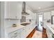 Stylish kitchen with white cabinets, stainless steel hood, and decorative backsplash at 7191 Three Kings Rd, Fort Mill, SC 29715