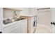 Laundry room with stainless steel sink, white cabinets, counter top, and washer and dryer at 7191 Three Kings Rd, Fort Mill, SC 29715