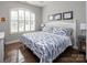 Bright and airy bedroom features a decorative bedspread, a bedside table, and natural light from the large window at 7535 Rabbit Cir, Denver, NC 28037