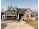 Gray craftsman style home with stone accents, a 3-car garage, and a landscaped yard at 7535 Rabbit Cir, Denver, NC 28037