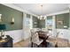 Bright dining room features an elegant chandelier, chair rail, and large windows with white curtains at 821 Bethesda Rd, Statesville, NC 28677
