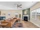 Living room with a brown leather sectional sofa, a fireplace, and large windows at 821 Bethesda Rd, Statesville, NC 28677