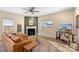 Living room with a brown leather sectional sofa, a fireplace, and large windows at 821 Bethesda Rd, Statesville, NC 28677