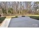 Backyard with fire pit, concrete patio, and wooded area at 8720 Tamarron Dr, Charlotte, NC 28277